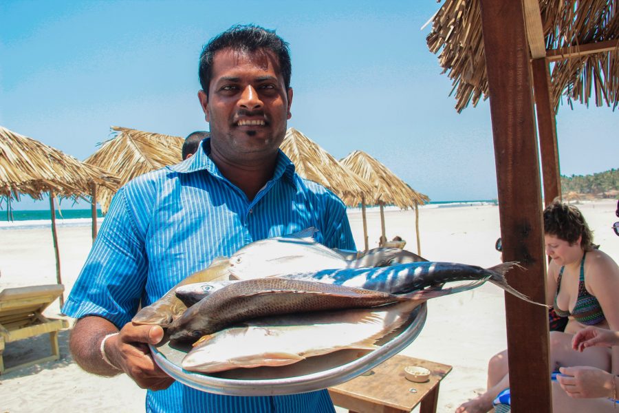 Man with fresh fish at a beach shack