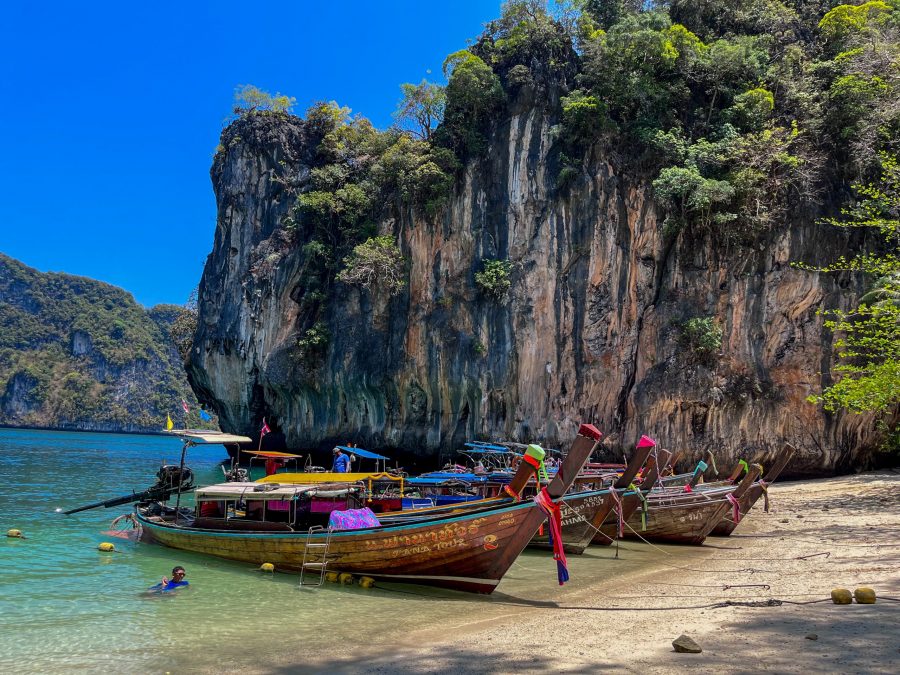 Traditional long-tail boats lined up on a picturesque Thai beach, ready for adventure on our 2-week Thailand itinerary.