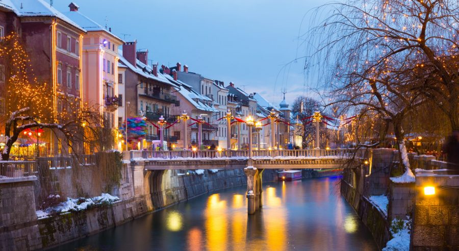 Ljubljanica riverbank in Ljubljana lit up with Christmas lights along the promenade - one of the hidden gem Christmas markets in europe