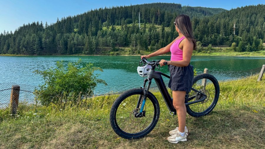Bicycle parked by the shore of Frumoasa Lake with mountains in the background