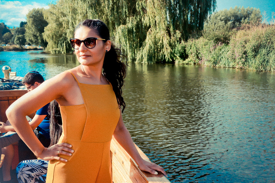 Person on a boat on the River Avon with lush riverside scenery in the background - Day Trips from London