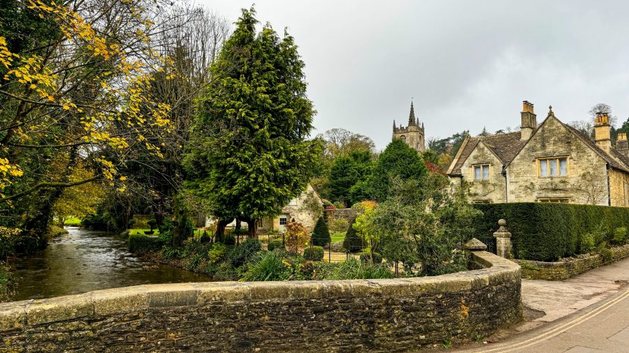 Scenic view of a Cotswolds village with historic cottages and lush greenery.