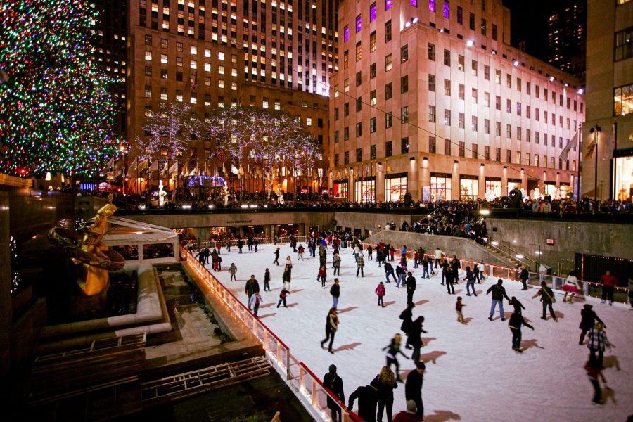 Ice skating at Rockefeller Center during Christmas in New York, surrounded by lights and holiday decorations.