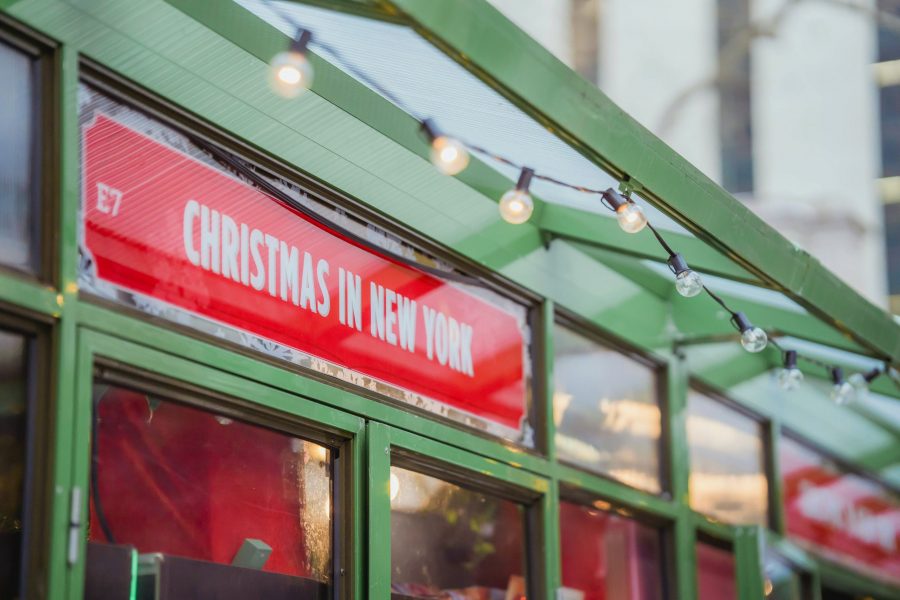 Festive shop sign decorated for the holidays in New York, with a warm seasonal vibe.