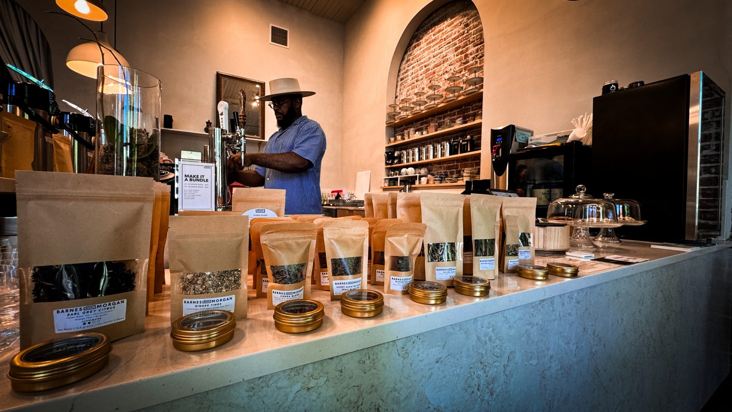 Various teas with man behind the tea shop counter