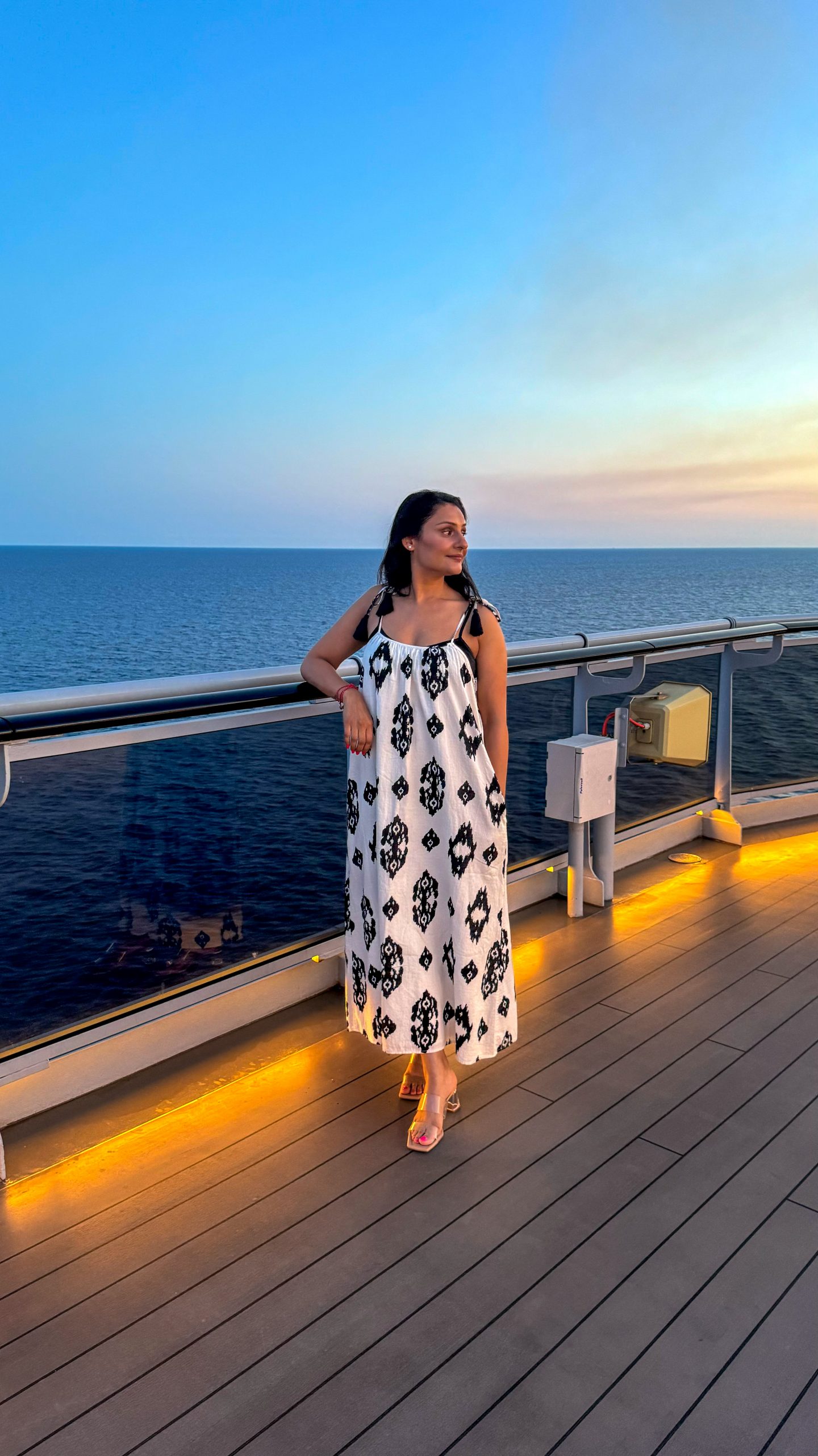 Rosie on the upper deck of Virgin Voyages Scarlet Lady during sunset in the evening
