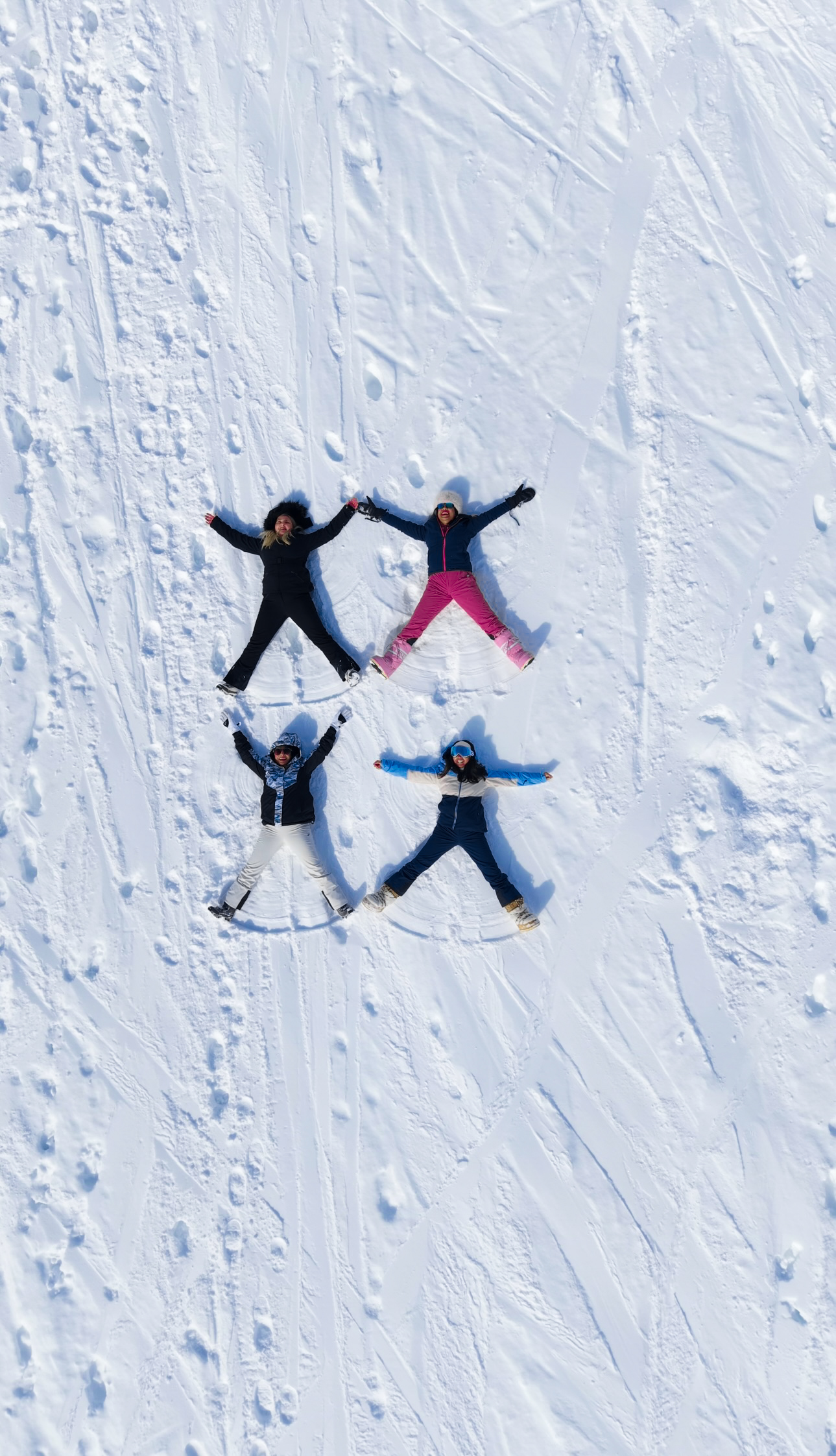 four girls doing snow angels in the snow