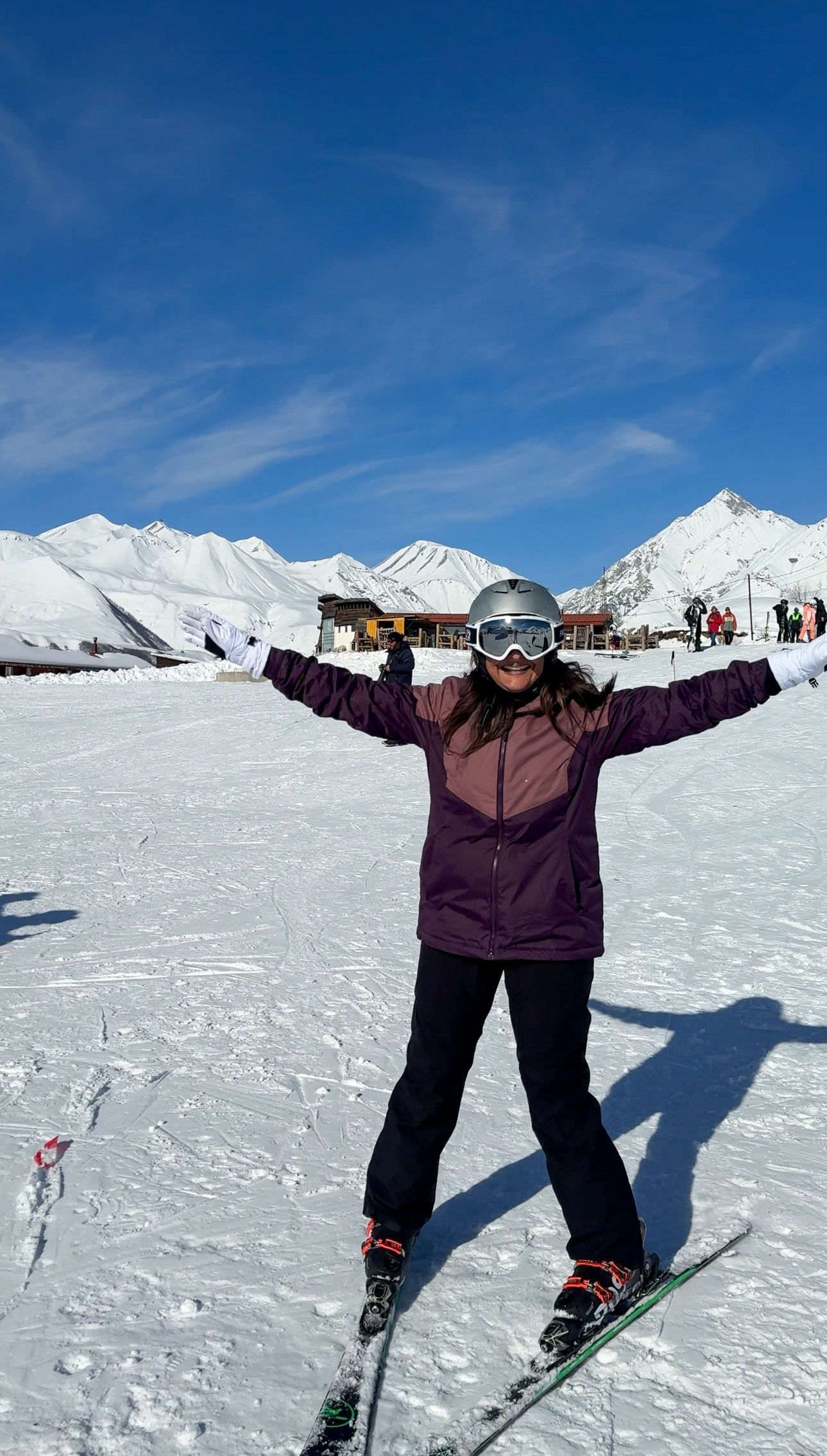 Woman smiling in ski gear and on skis for the first time skiing in Gudauri