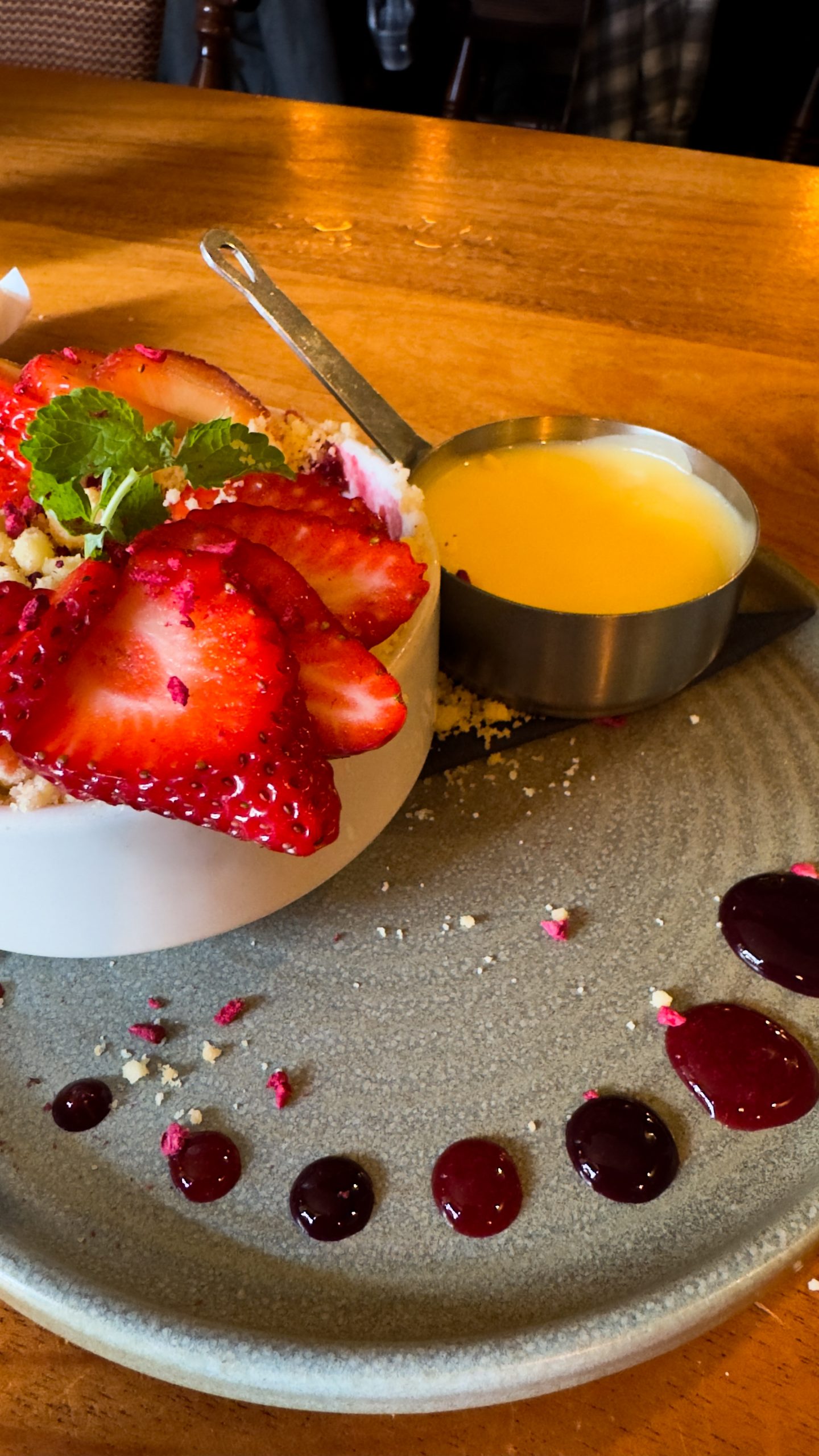 Strawberry and Raspberry crumble and custard on a plate at the Yorkshire Bridge Inn