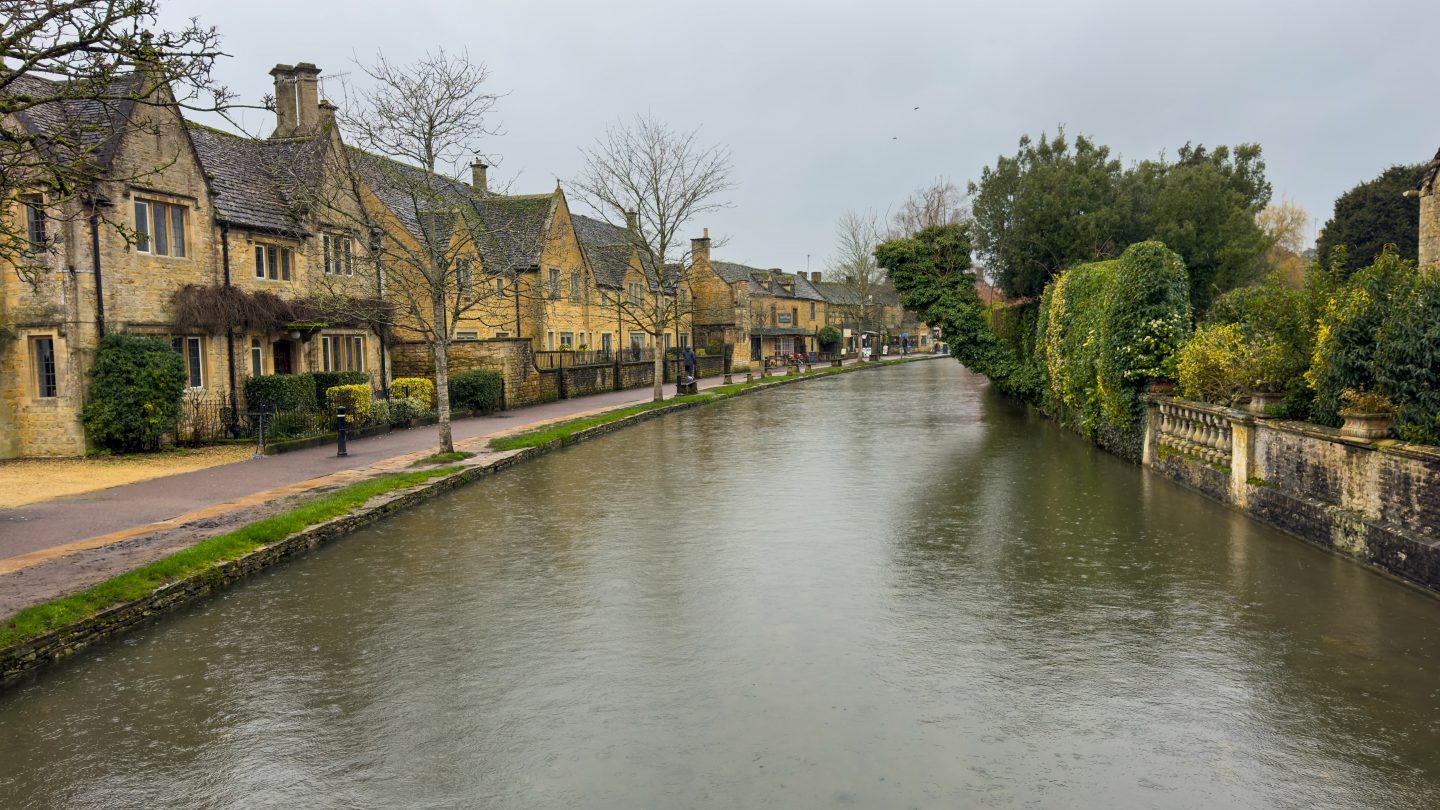 Bourton on the water river and stone-coloured buildings on a rainy day in the Cotswolds
