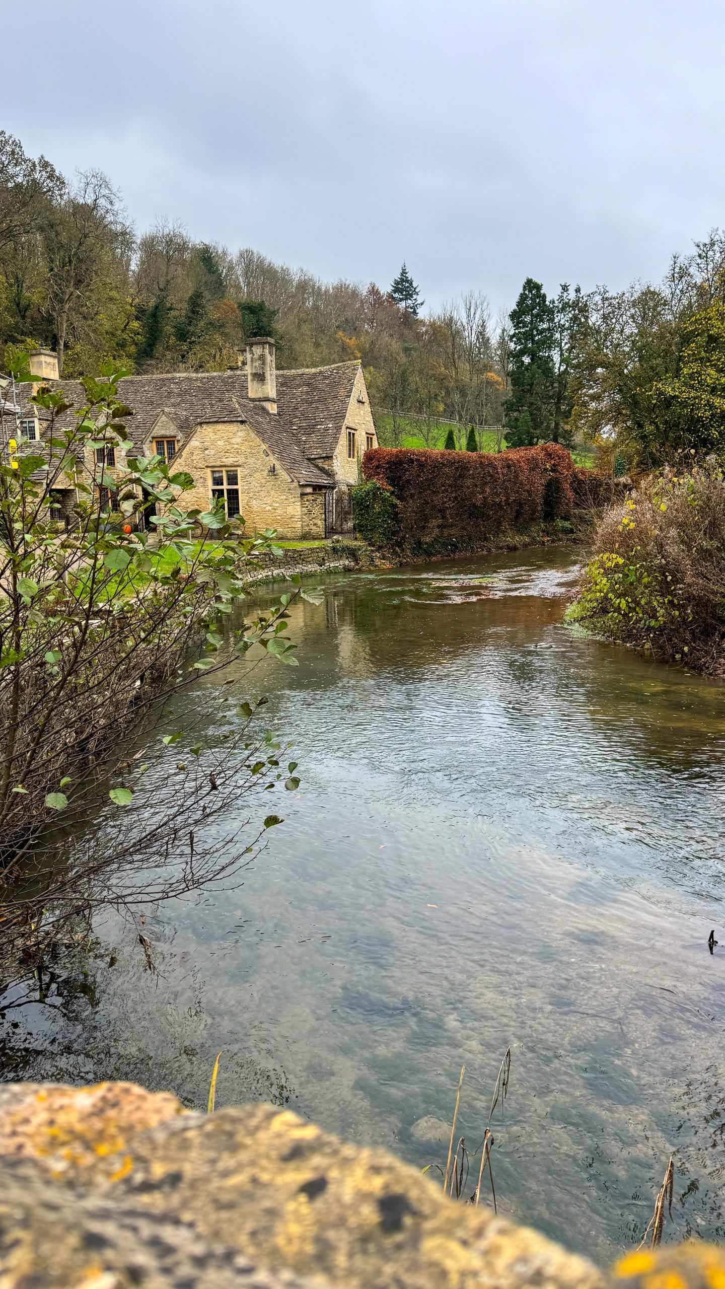 Stone coloured houses on the river in Castle Combe in the Cotswolds