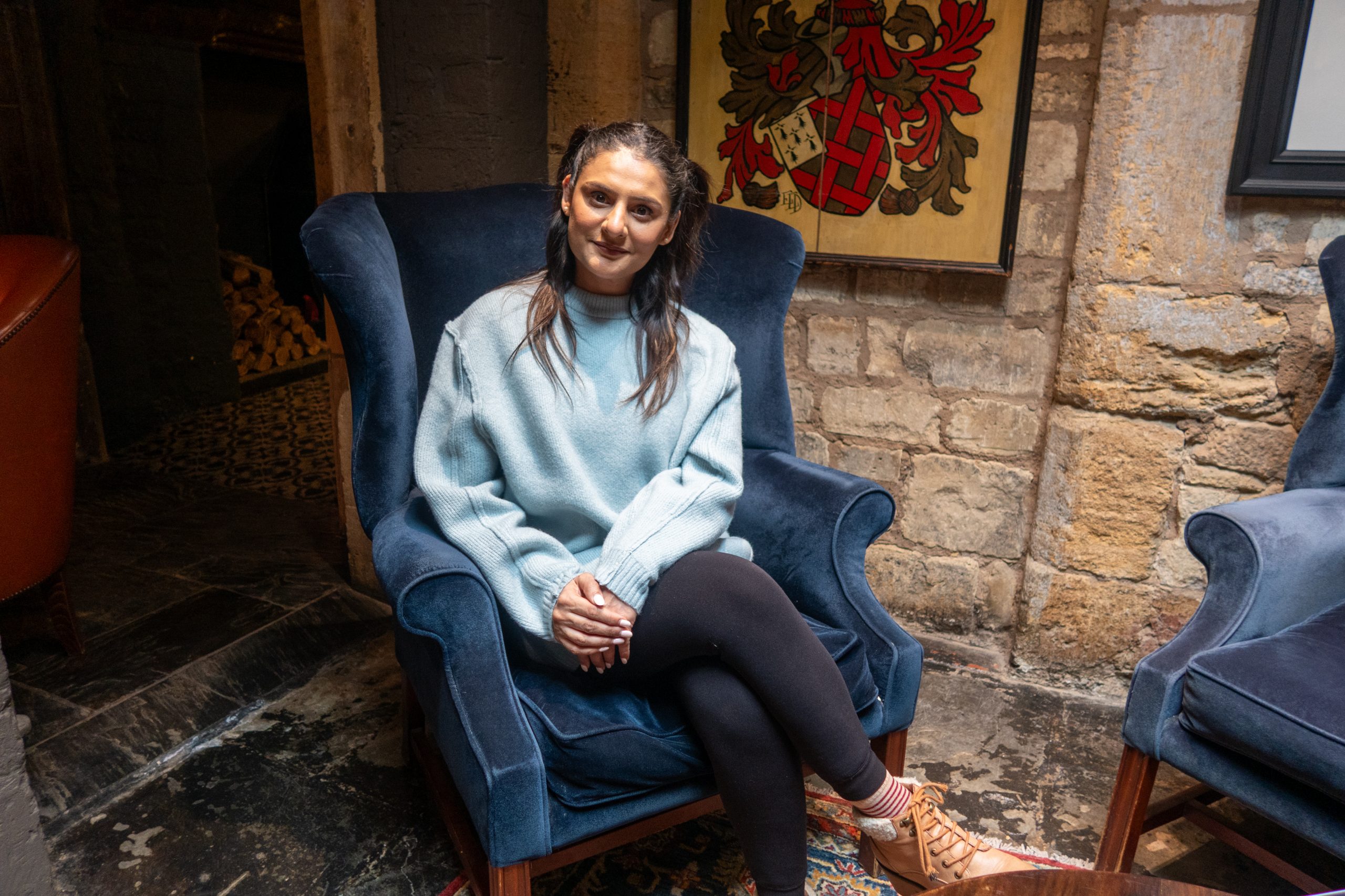 Woman sitting on a blue chair at The Lygon Arms
