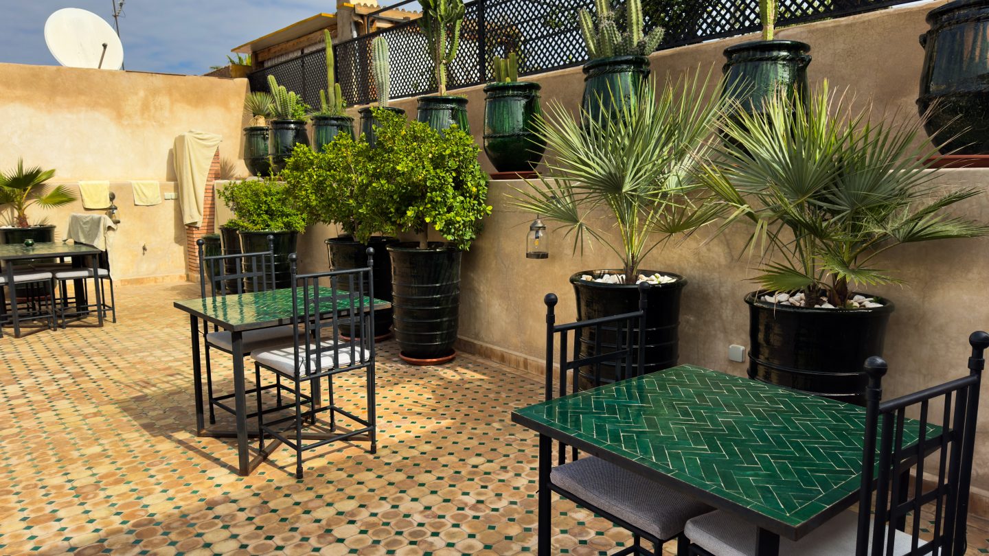Rooftop and tables of a Marrakesh riad with tiled fountain and seating