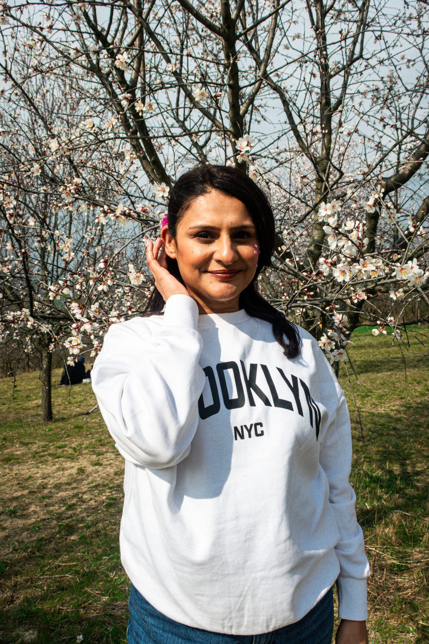 A woman standing in an Almond orchard during blossom season in South Moravia Wine Country