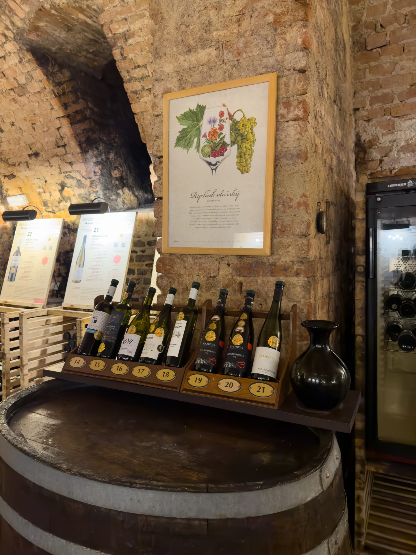 Wine bottles on top of a barrel in the National wine salon in Valtice Chateau
