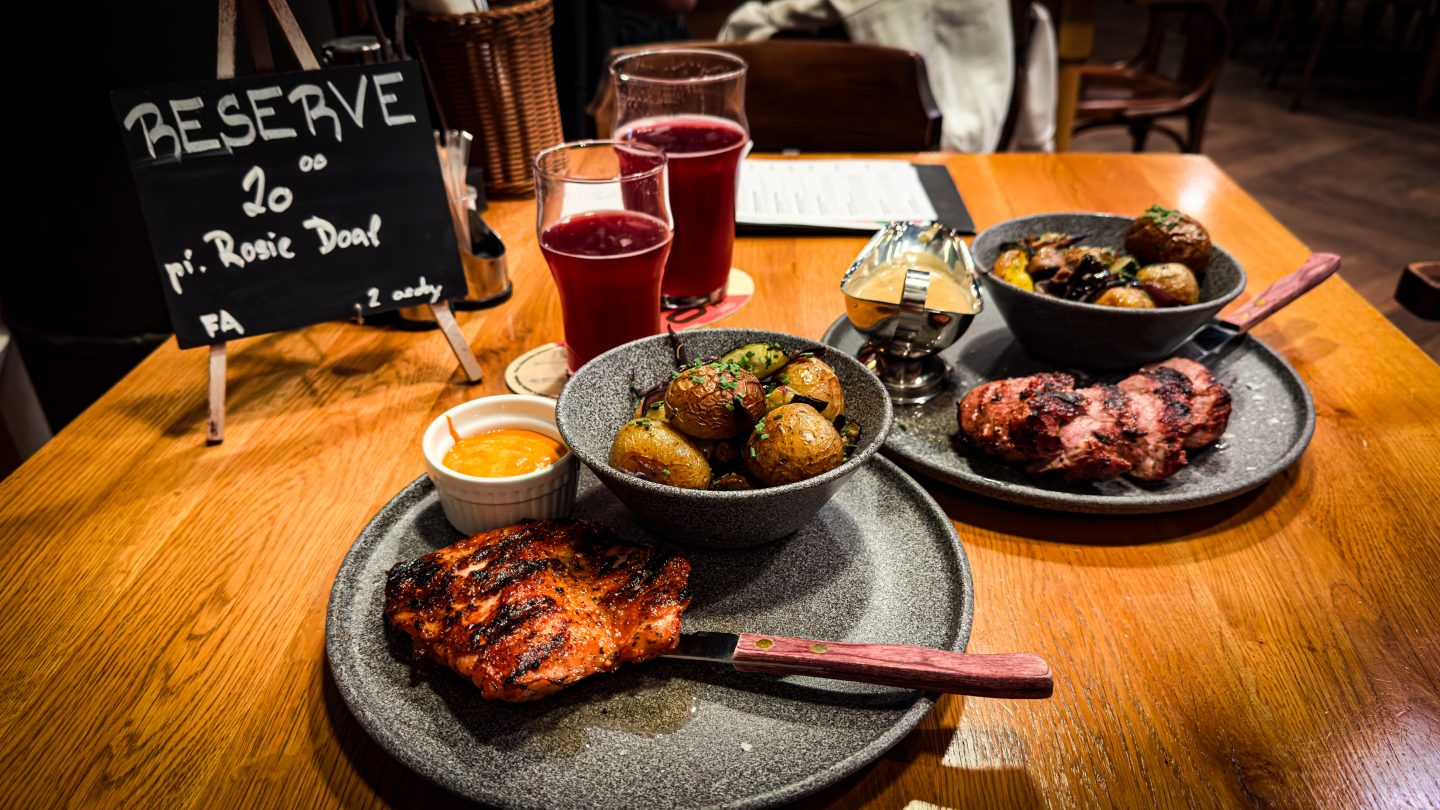 Meat and potato dinner on a plate with lager pints