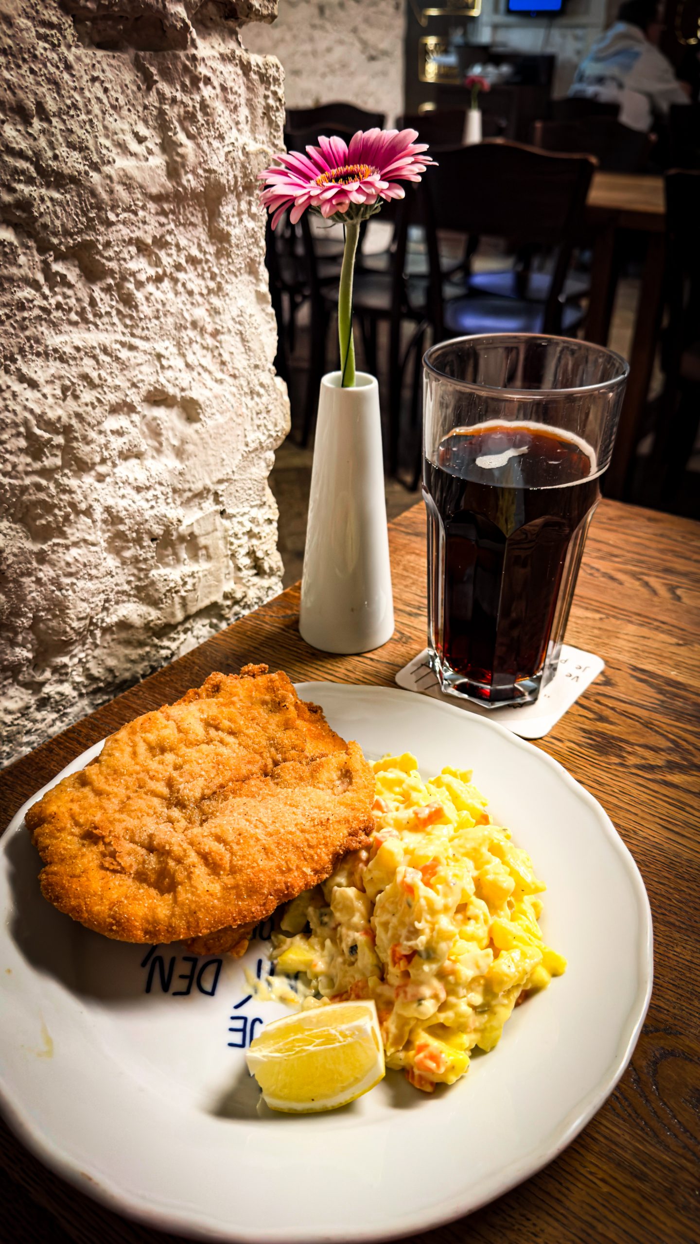 Chicken schnitzel and potato salad on a plate with Kofala