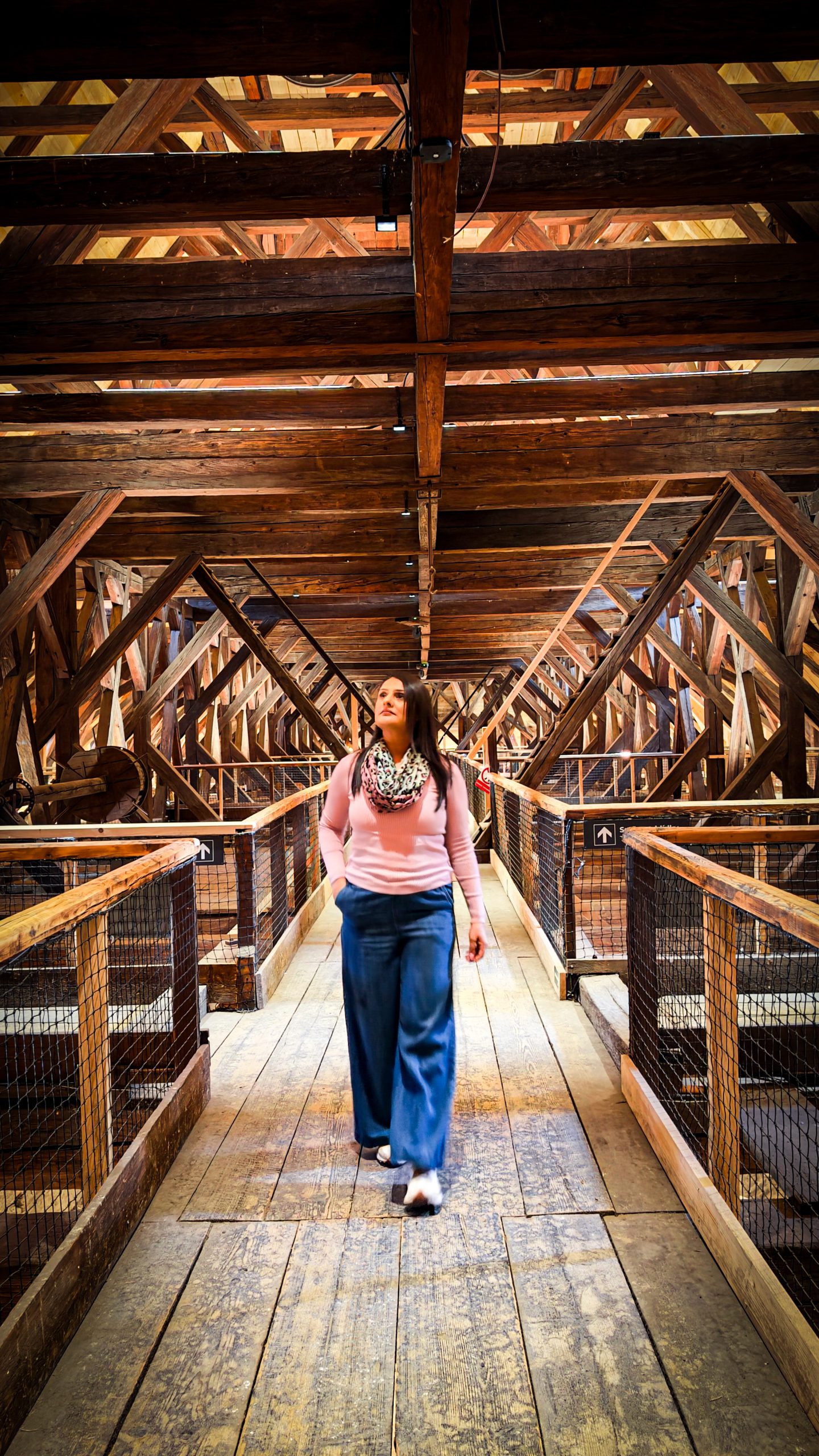 A woman standing in the attic between the trusses at St James Church, Brno