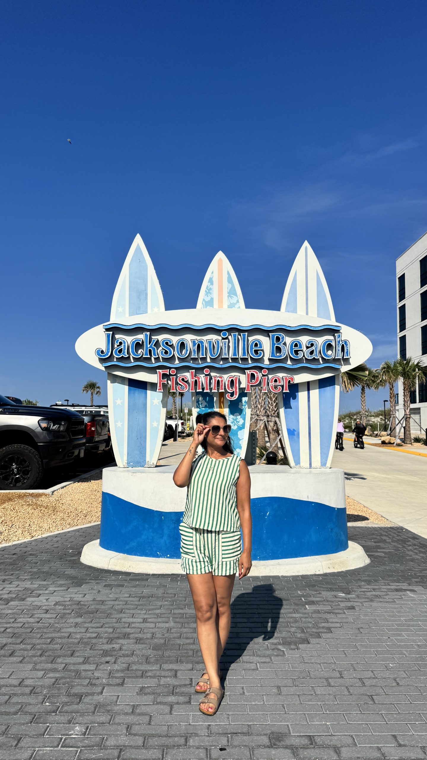 Woman standin in front of the Jacksonville Beach and Pier sign