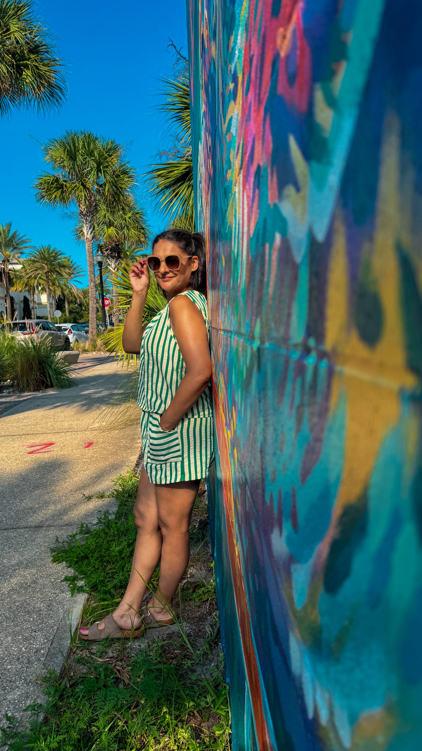 Woman standing in front of a mural on the Mural Art Trail on Jax Beach